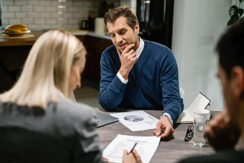 Adviser and couple reviewing paperwork for their next property move